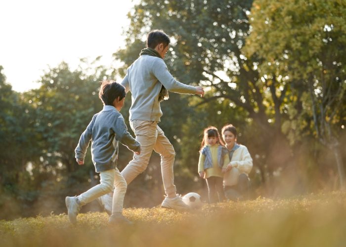 Asian,Father,And,Son,Playing,Soccer,Football,Outdoors,In,Park